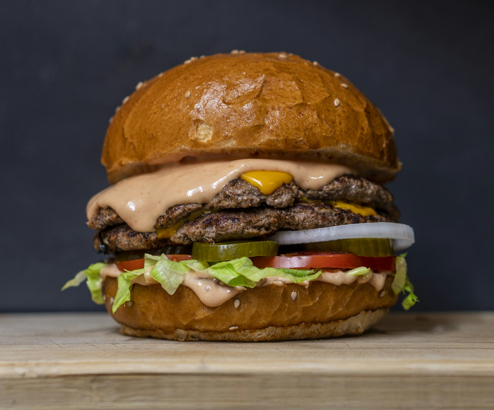 Stacked cheeseburger with lettuce, tomato and pickles