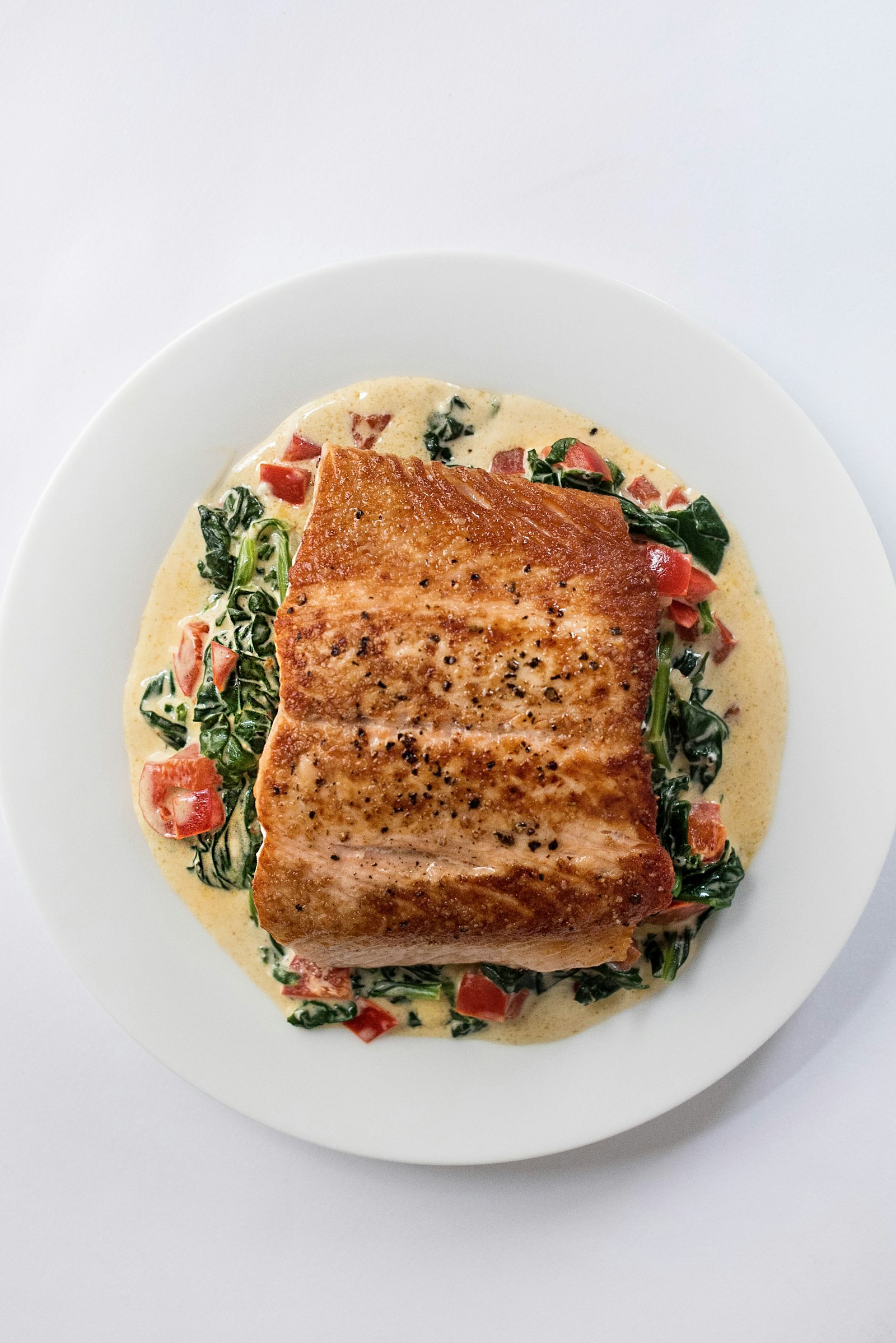 Seared salmon fillet plated over creamed greens